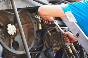 Mechanic using wrench on heavy vehicle wheel hub for brake repair service