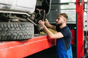 Mechanic working under vehicle lift for mobile truck repair service